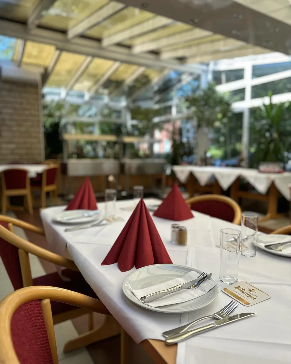 Festlich eingedeckte Tafel im Restaurant Haus Wessels mit weißem Leinen und bordeauxroten Servietten