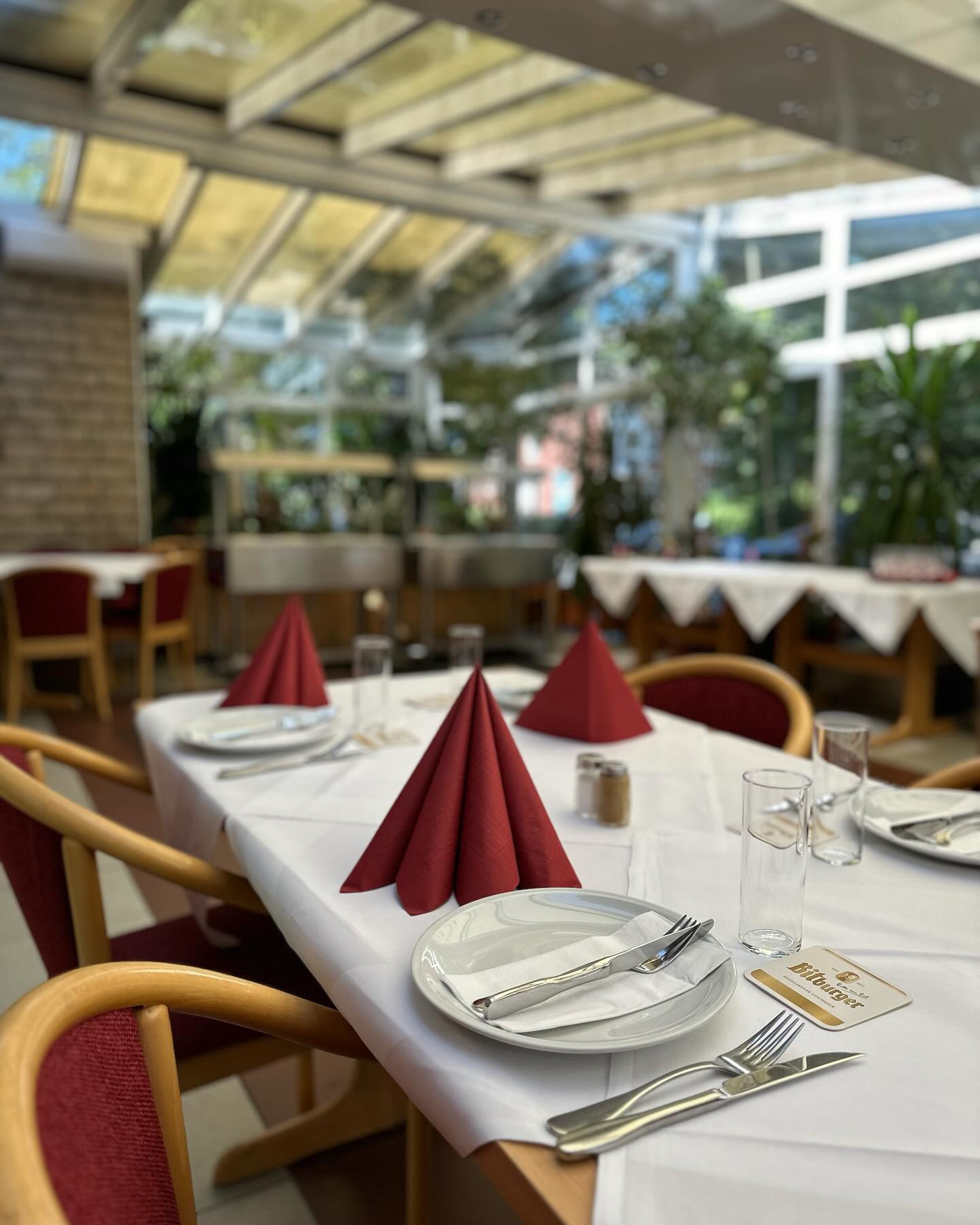 Festlich eingedeckte Tafel im Restaurant Haus Wessels mit weißem Leinen und bordeauxroten Servietten